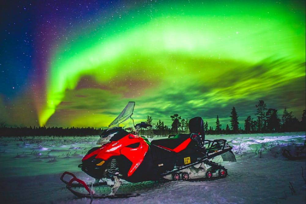 Viagem de fotografia de moto de neve com a aurora