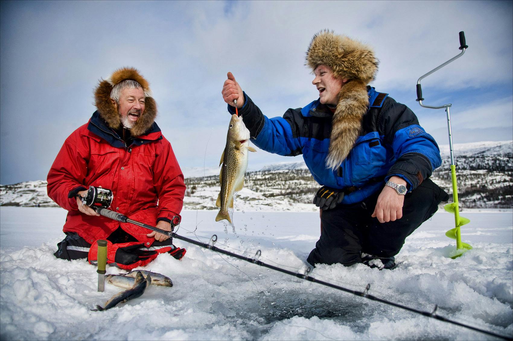 Experience ice fishing on a frozen lake in the Arctic forest. 