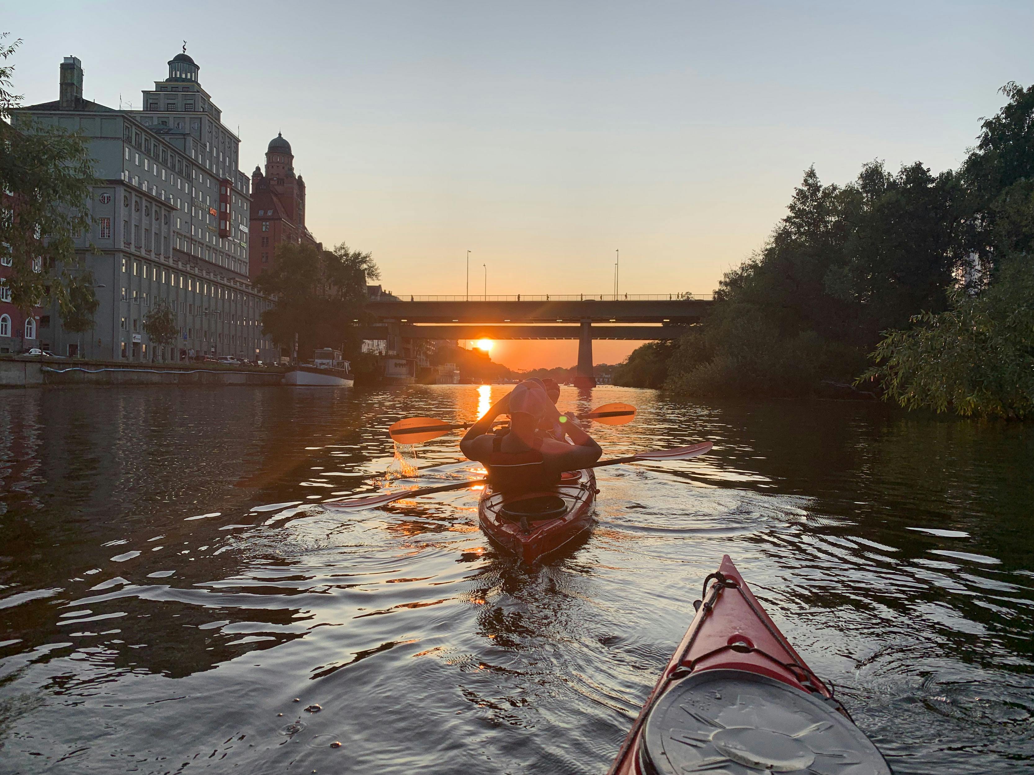 Guidad ekovänlig kajaktur i Stockholm-City vid solnedgången