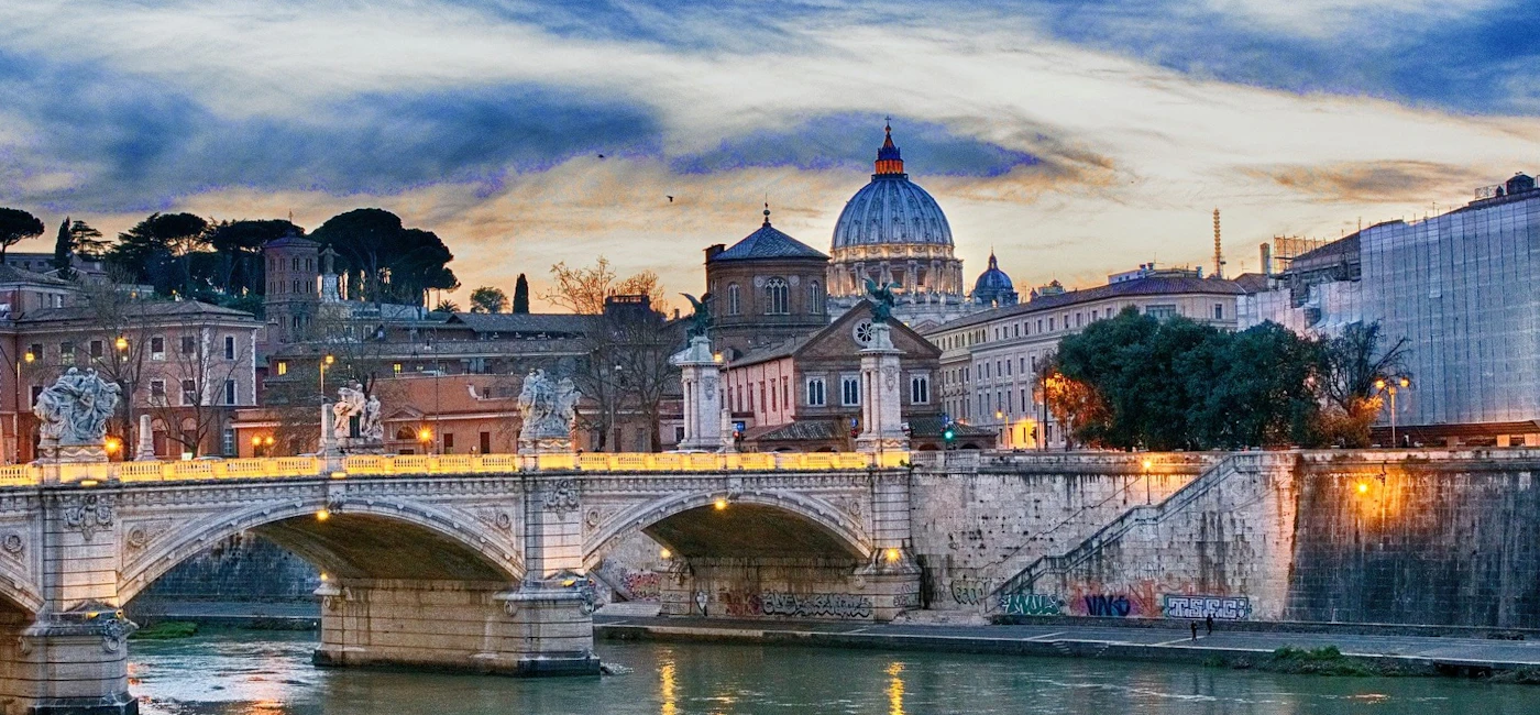 Evening view over the Tiber River in Rome with bridge and St Peter’s dome in the background