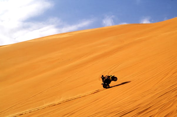 Red dunes quad bike tour with camel ride, sandboarding and BBQ in the Dubai desert