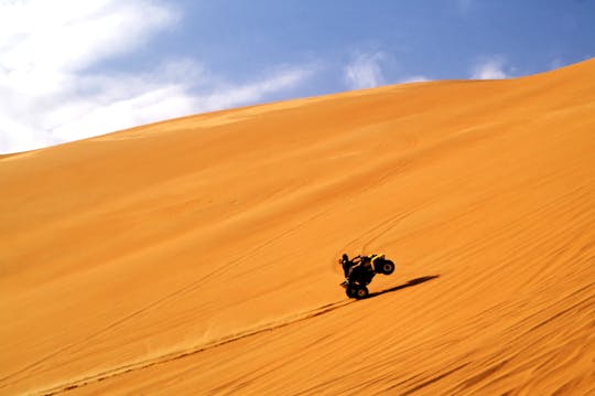 Half-day red dunes quad bike tour with camel ride, sandboarding and BBQ