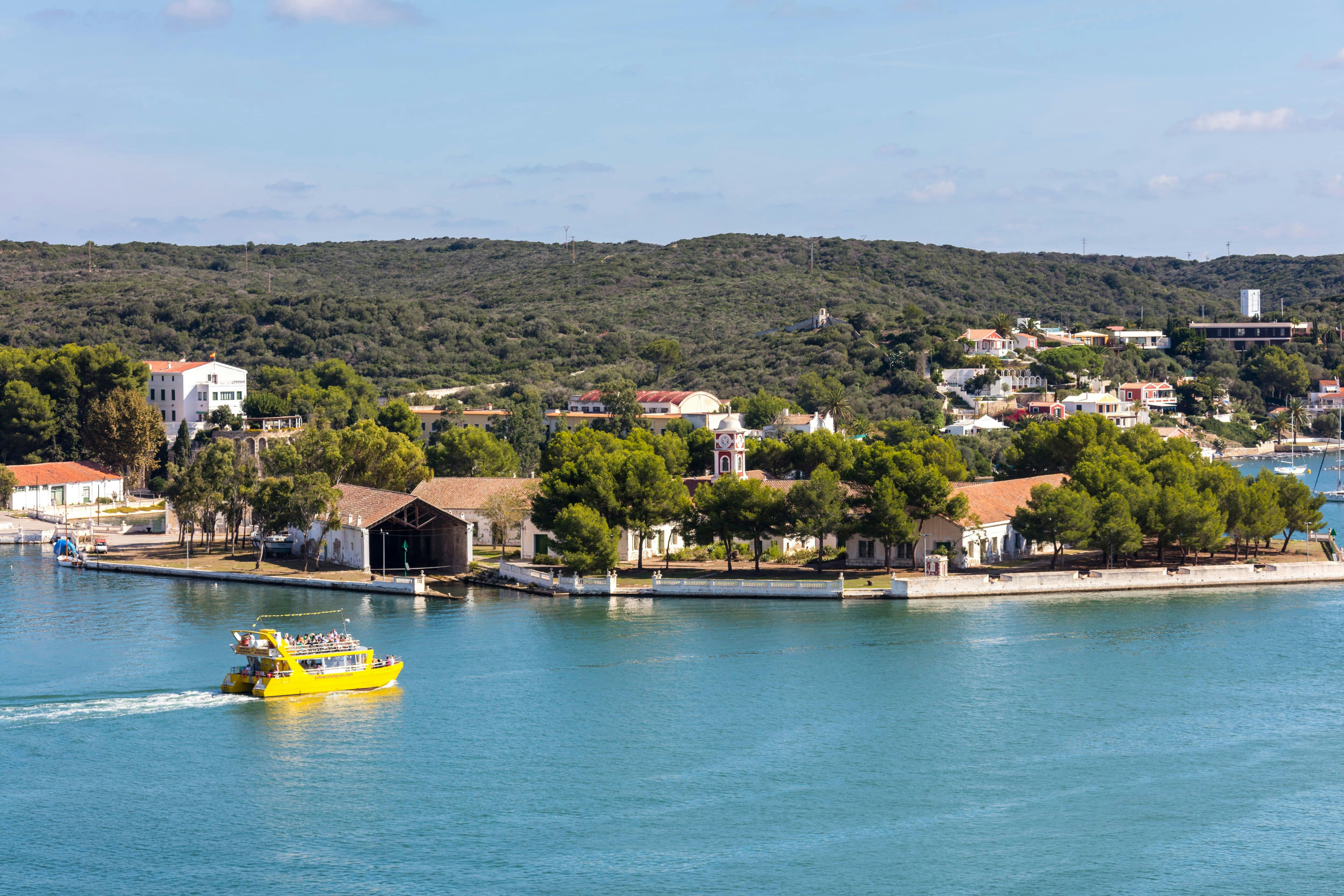 Cruzeiro de catamarã amarelo no porto de Mahon com vista subaquática