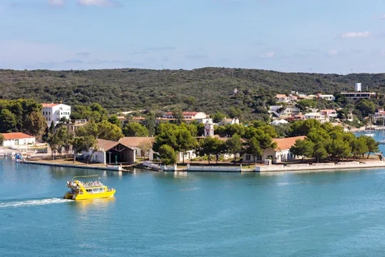 Cruzeiro de catamarã amarelo no porto de Mahon com vista subaquática