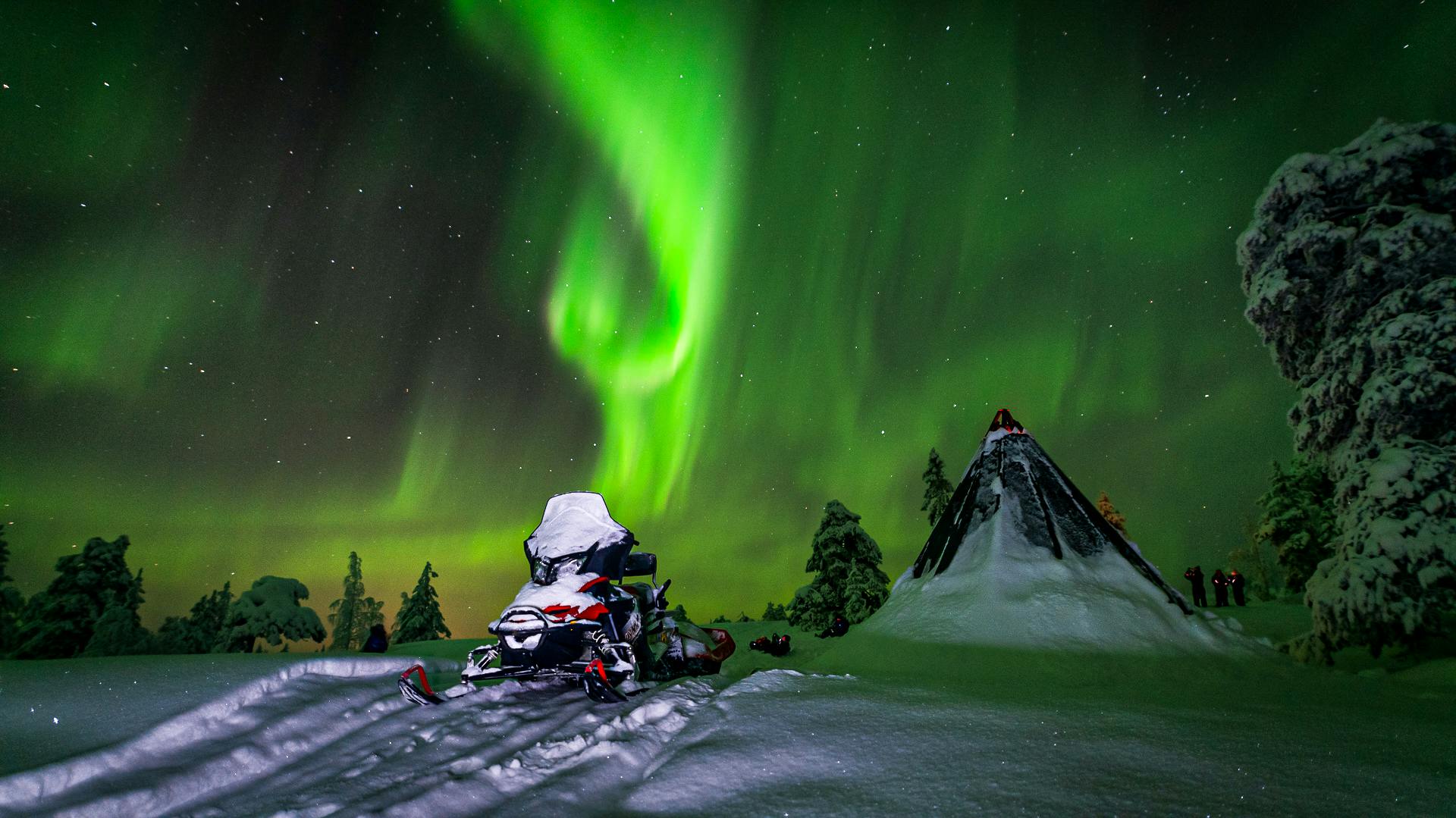 Aurora boreal caça de moto de neve em Saariselka