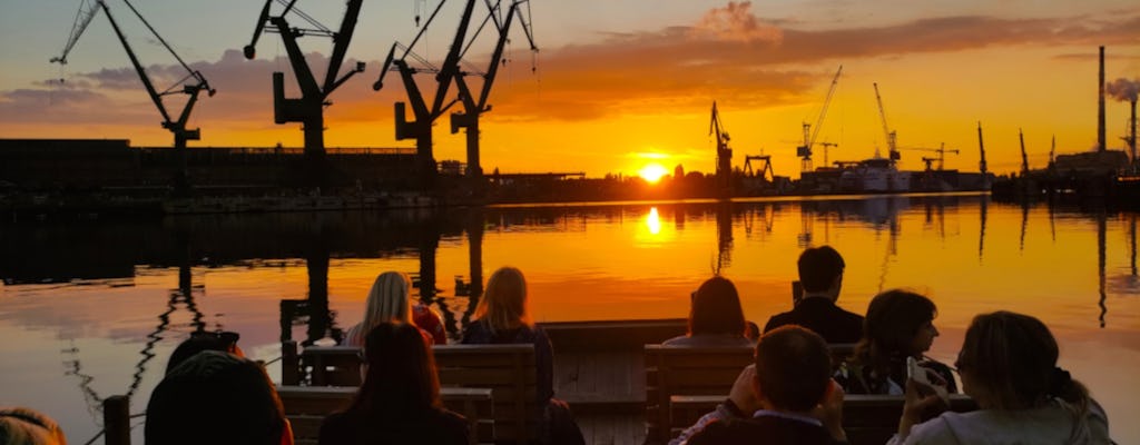 Pôr do sol no estaleiro e cruzeiro na cidade velha de Gdansk