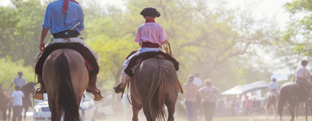 Gauchos riding horses during an Argentinian estancia experience