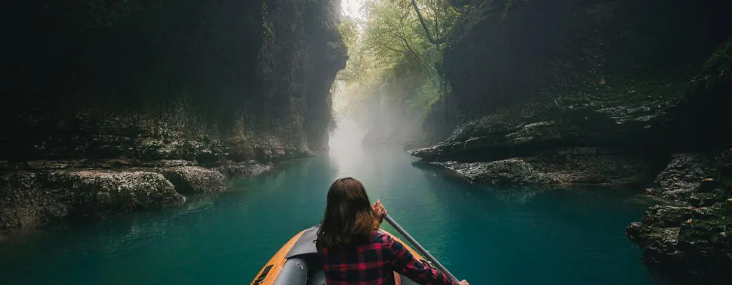 Boat on turquoise water inside Martvili Canyon in western Georgia