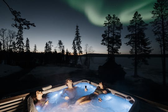 Experiência de sauna e banheira de hidromassagem na floresta ártica com aurora boreal