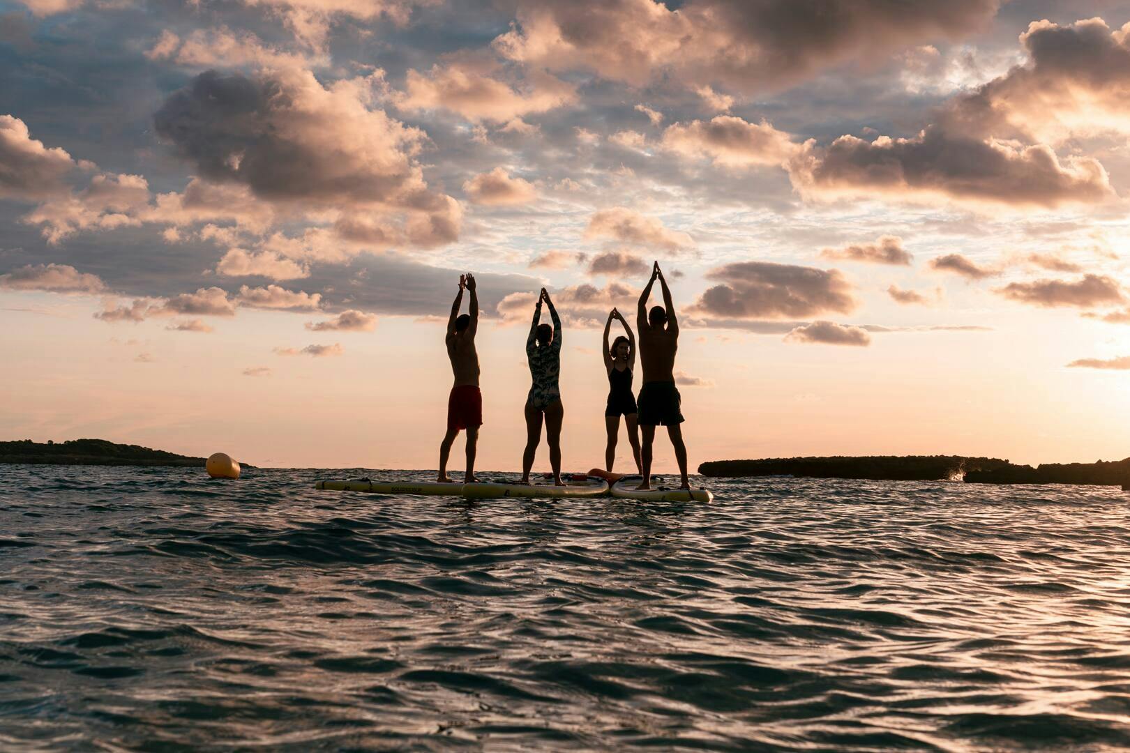 Yoga in stand-up paddleboard al largo della costa orientale di Maiorca