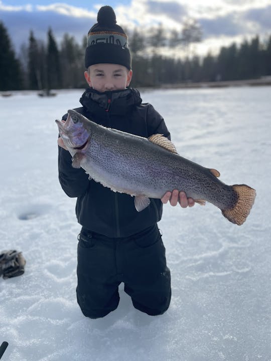 Ice fishing on frozen water with local guide