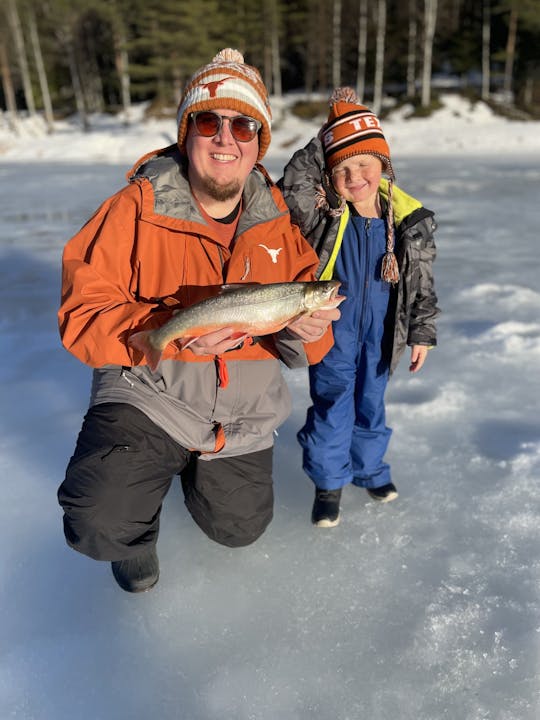 Ice fishing on frozen water with local guide