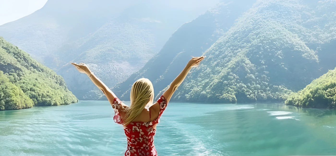 Turquoise water and steep green mountains on Koman Lake and the Shala River day trip from Tirana
