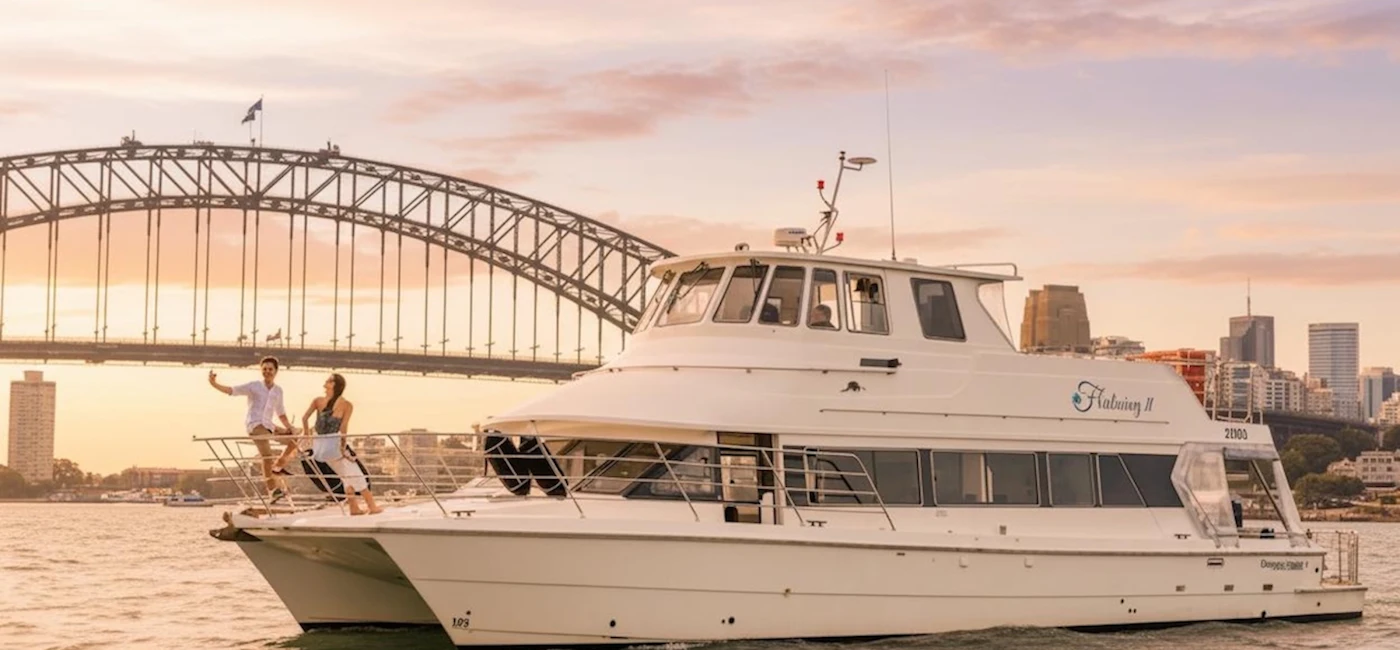 Fleetwing II catamaran on Sydney Harbour at sunset near the Harbour Bridge
