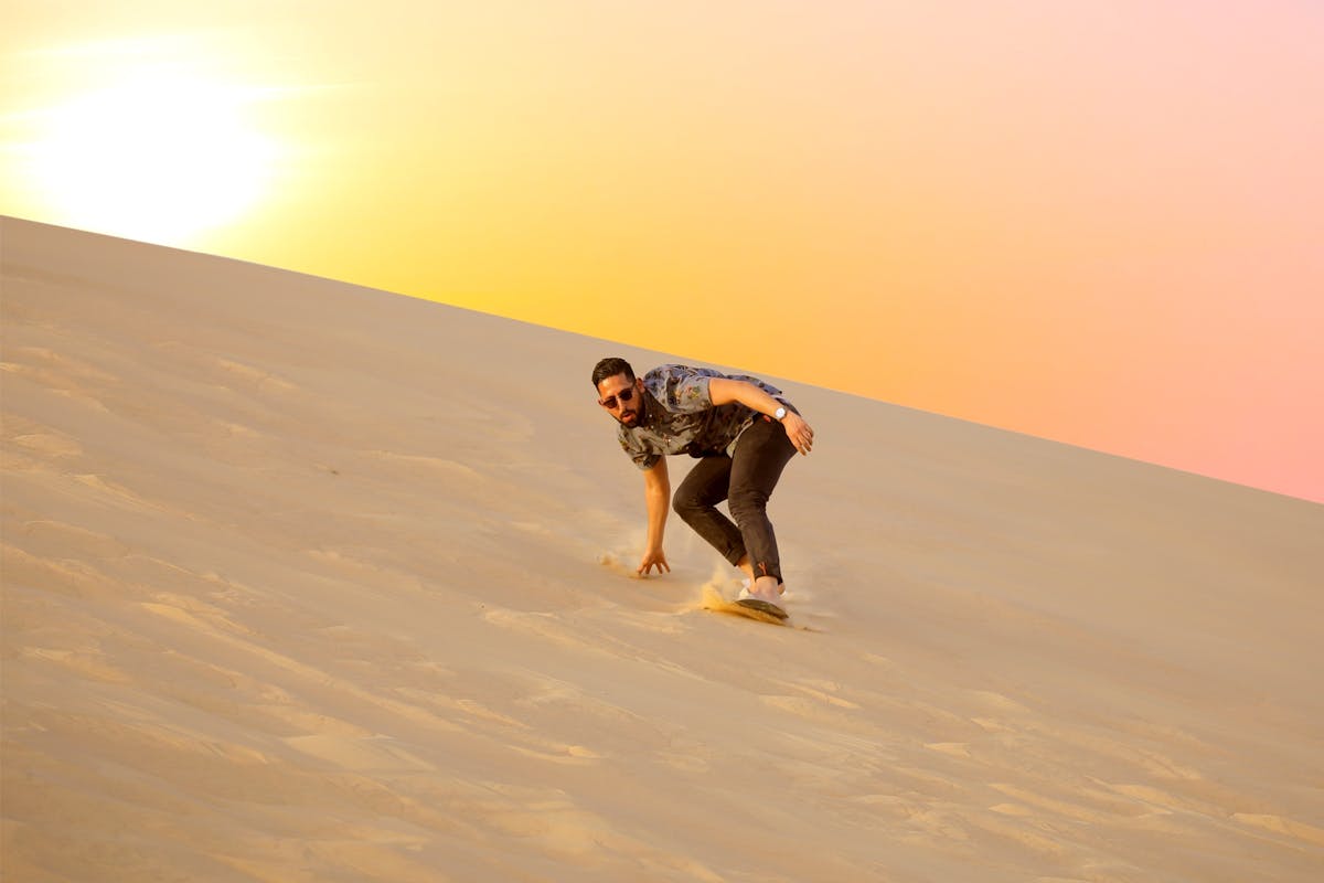 Woestijnavontuur in Abu Dhabi bij zonsopgang met duinafdaling en kamelentocht