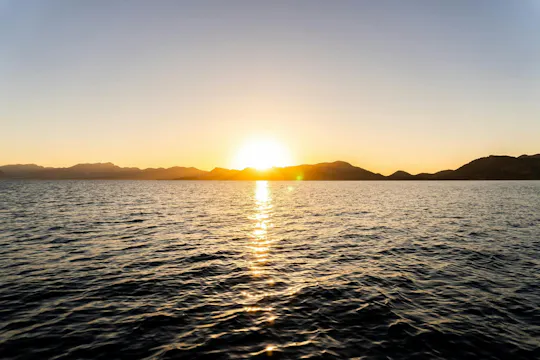 Tour in barca al tramonto lungo la costa mediterranea