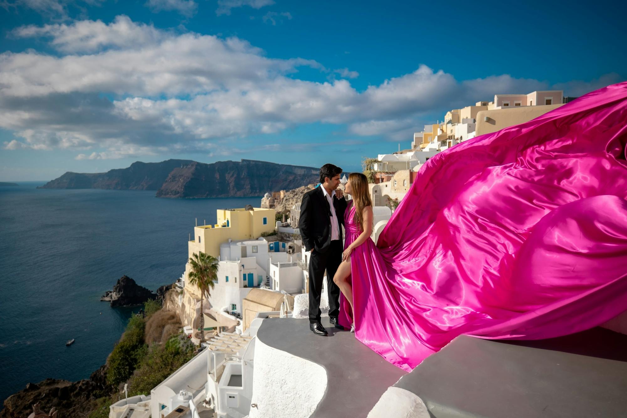 Sessão fotográfica com vestidos esvoaçantes em Santorini, com vistas para a caldeira e para Oia