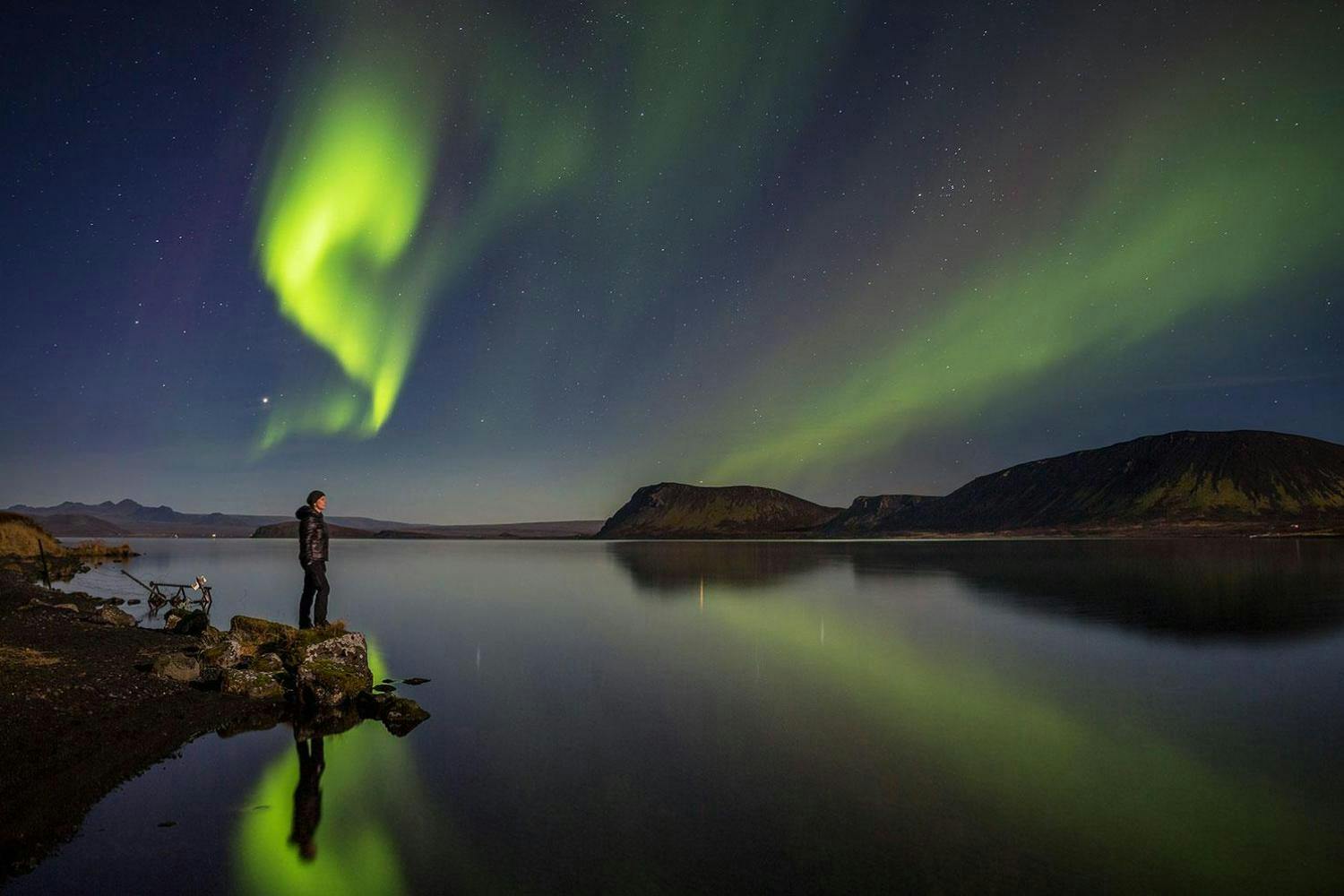 Iceland northern lights tour woman by lake with aurora.jpg