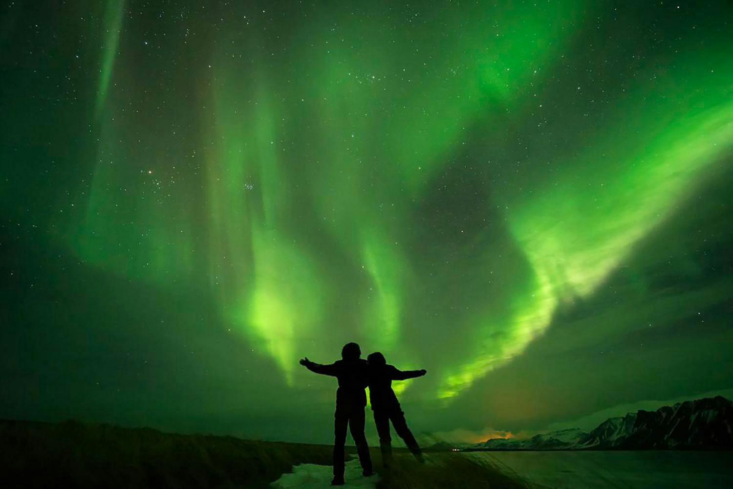 Iceland northern lights tour happy people under a sky full of aurora.jpg